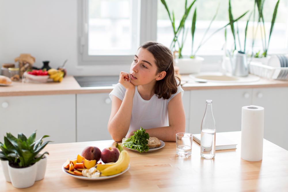Benefits of interval fasting The girl sits at her desk and ponders