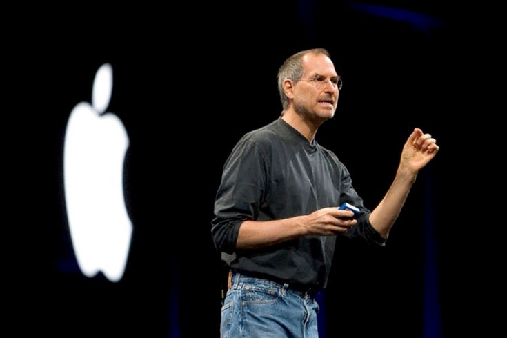 Стив Джобс с яблоком на черном фоне